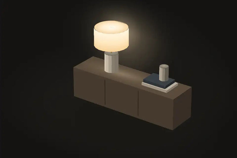 A table lamp glowing on an oak sideboard
