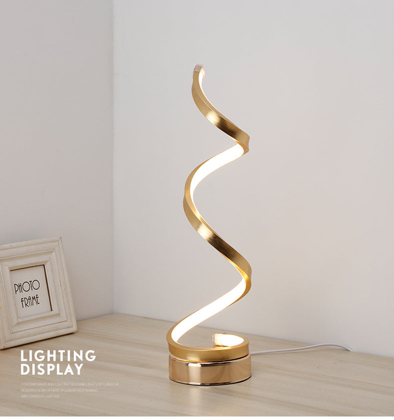 Moodly Helix spiral LED table lamp in gold on a wooden desk