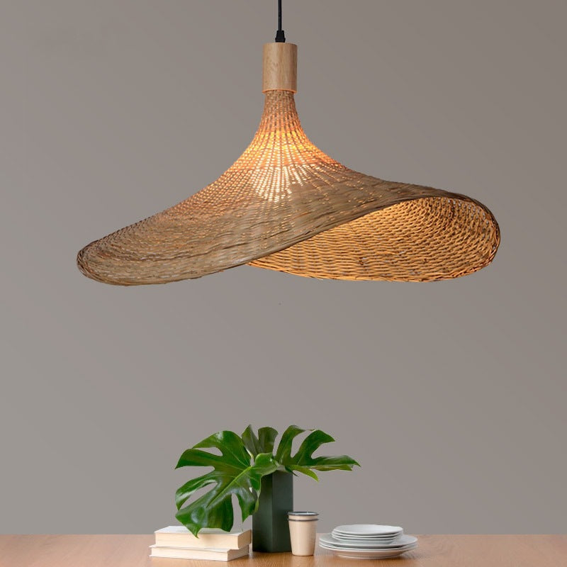 Moodly Wave bamboo pendant light above a table with a plant