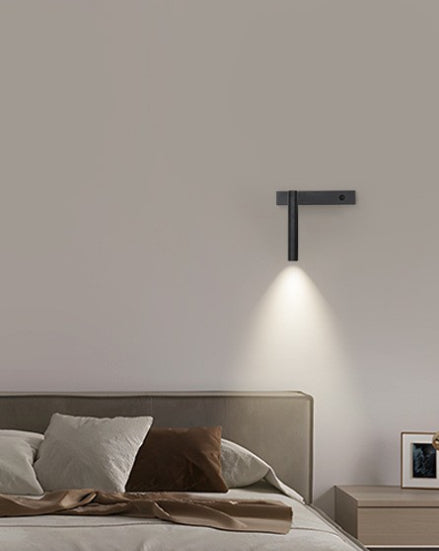 Black Moodly Beam wall reading light shining down beside a bed