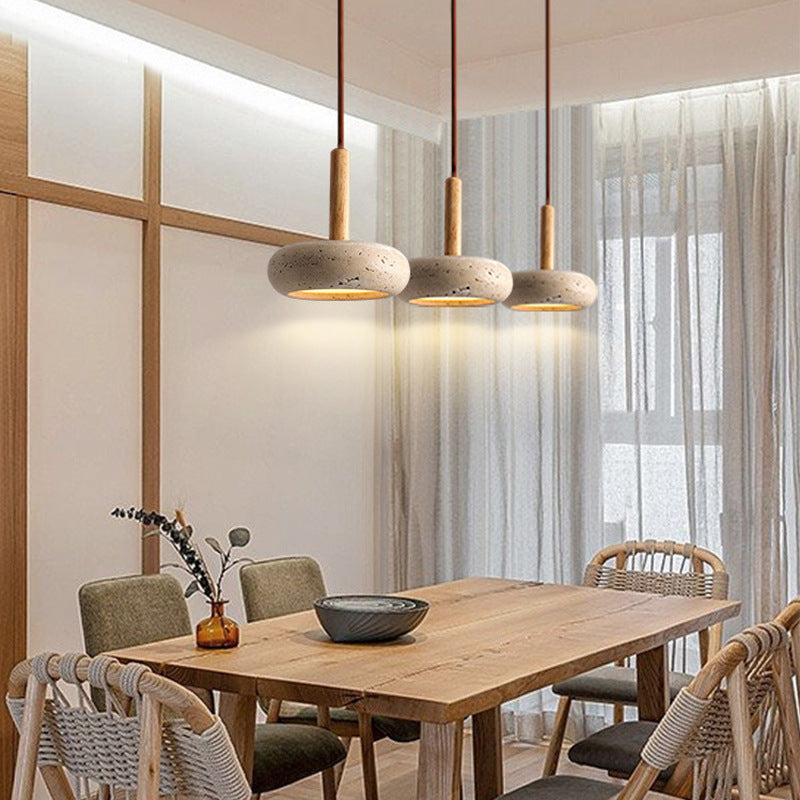 Three Moodly Pebble stone and wood pendant lights above a wooden dining table