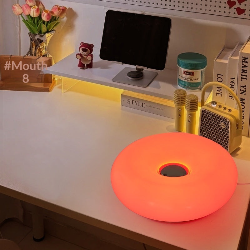 Moodly Puff donut lamp glowing red on a desk