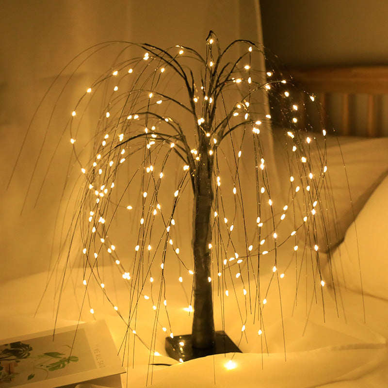 Black Moodly Willow LED tree lamp glowing warm in a bedroom