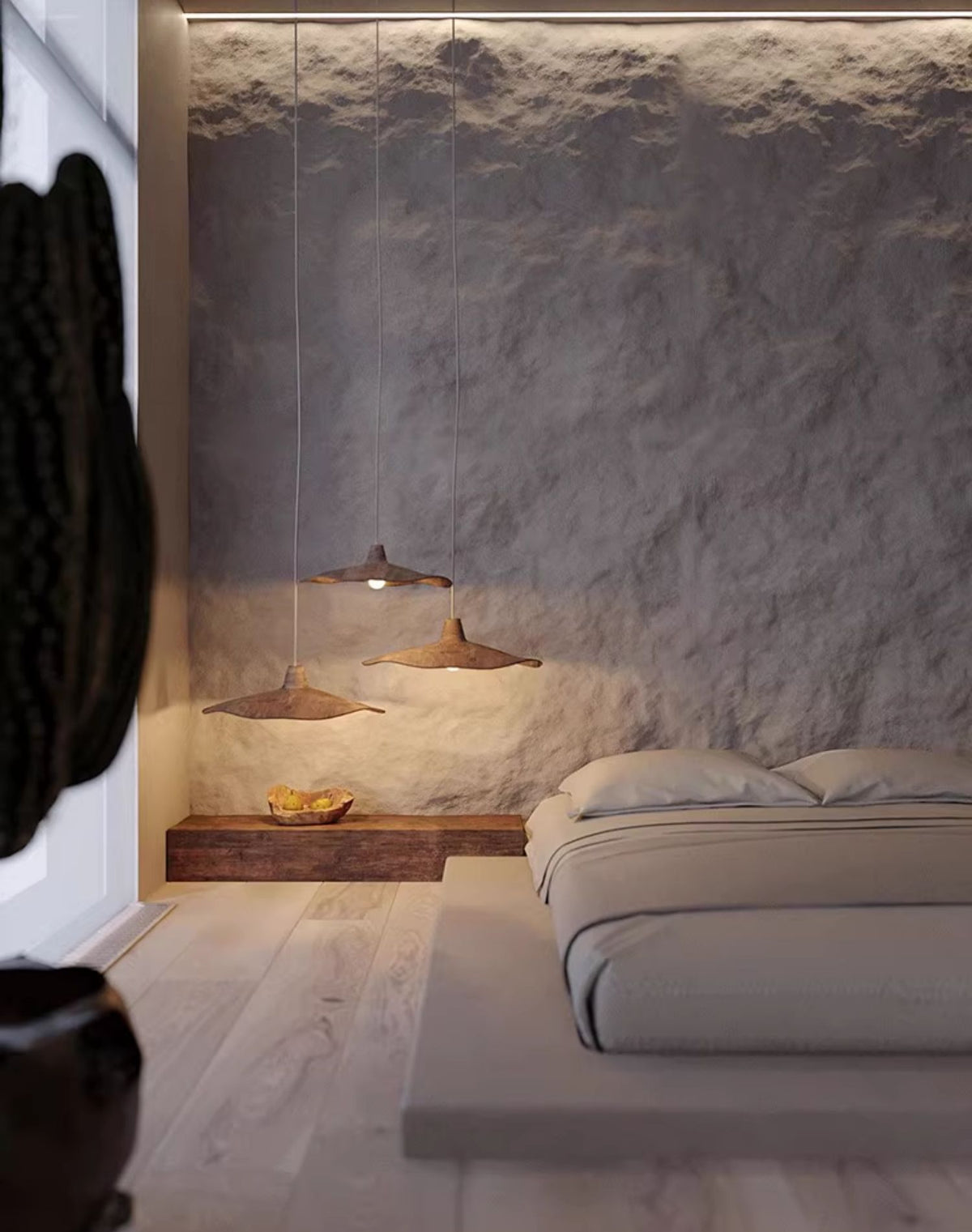 Moodly Dune pendant light hanging low beside a bed
