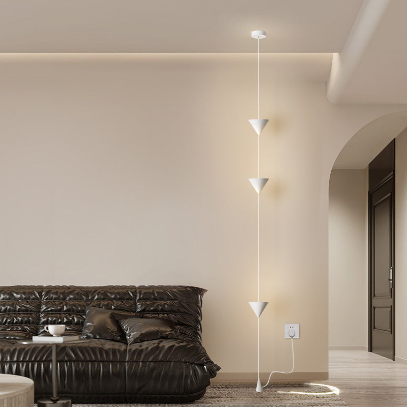 Moodly Line lamp glowing next to a dark sofa