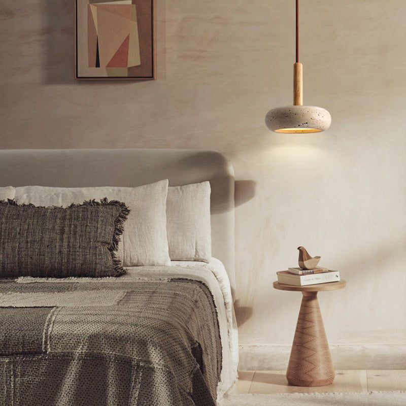 Moodly Pebble stone pendant light hanging beside a bed