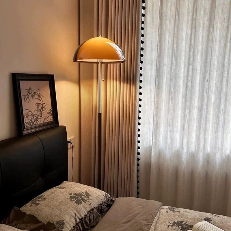 Moodly Amber floor lamp glowing beside a bed