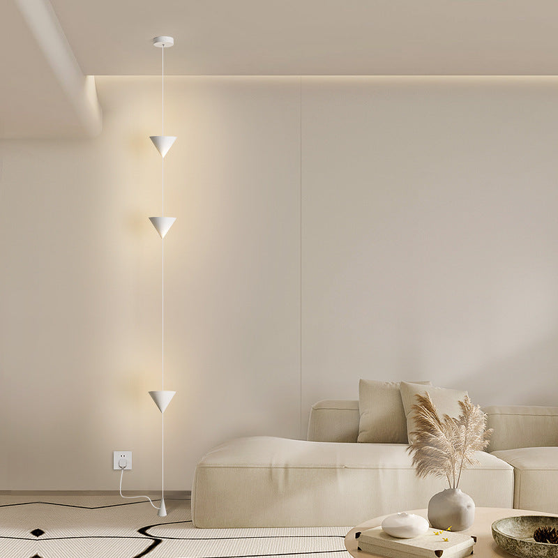 Moodly Line floor-to-ceiling lamp with three cone lights beside a sofa