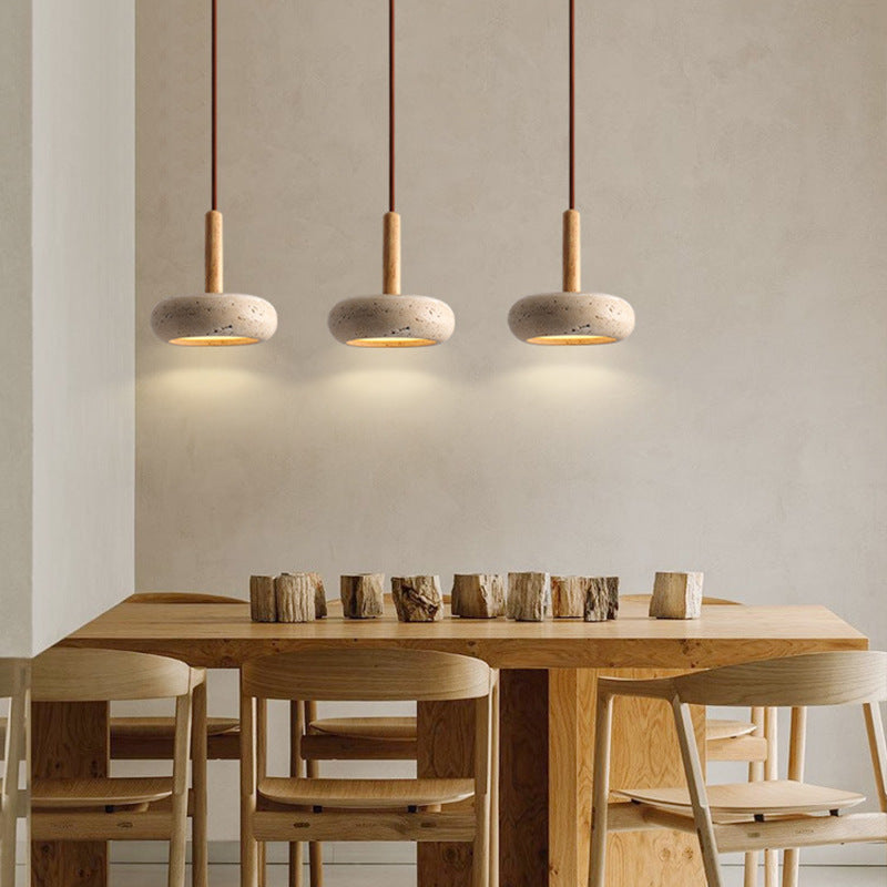 Three Moodly Pebble pendant lights in a row above a long dining table