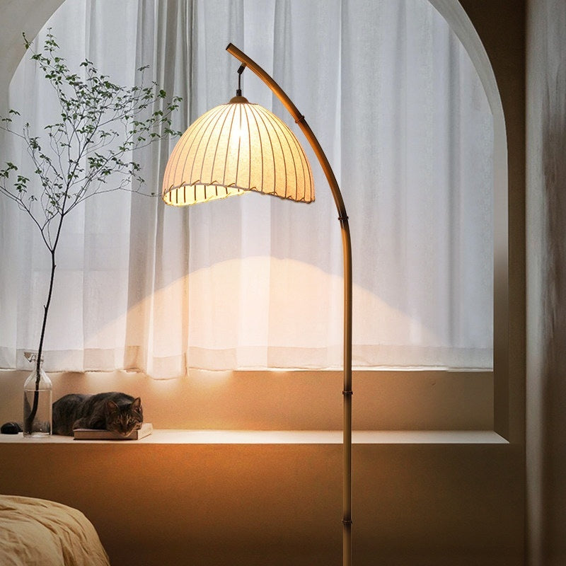 Moodly Arc floor lamp glowing warm in front of an arched window