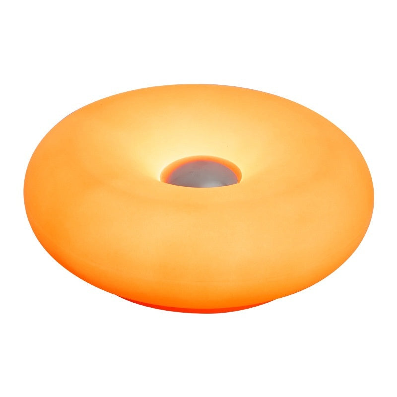 Moodly Puff donut lamp glowing orange on a white background