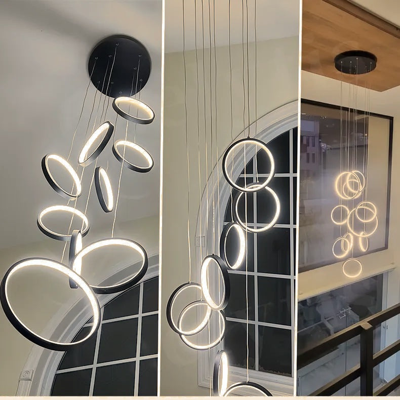 Moodly Orbit LED ring chandelier installed in a stairwell and a double-height hall, glowing warm white